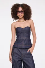 Top strapless de denim azul oscuro con escote corazón, costuras pespunteadas en color contrastante y corte peplum.