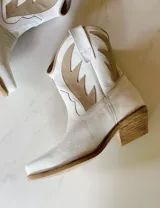 Bota corta estilo western de cuero color marrón, con taco cuadrado de 5 cm y diseño clásico. Presenta un acabado desgastado en la puntera y el talón.