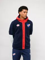 Campera de polar blanca con capucha y detalles en azul marino, con cierre frontal completo. Presenta el logo de Umbro y el escudo del Club Nacional de Football en el pecho.