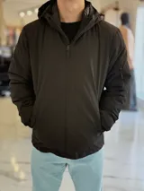 Campera 2 en 1 impermeable de color negro, con diseño con capucha y cierre frontal completo.