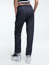 Pantalón de corte recto y tiro medio, confeccionado en denim de algodón con acabado texturizado en color tabaco. Presenta cierre frontal con botón y bolsillos laterales.