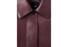 Chaqueta color bordó de poliuretano, tipo campera corta, con solapas anchas, cierre frontal con botones y bolsillos frontales con solapa.