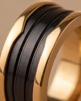 Anillo de acero con banda central ancha color negro y bordes con baño de oro.