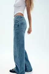 Jeans wide leg de tiro alto, color azul con efecto deslavado, cintura con trabillas, diseño de cinco bolsillos y cierre frontal con cremallera y botón metálico.