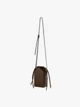 Bolso de hombro rígido color marrón, en piel de becerro lisa mate con correa plana, un compartimiento con cordones de piel y un bolsillo interior de parche.