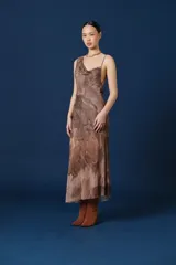 Vestido midi de tirantes con escote drapeado y espalda descubierta. Presenta un estampado abstracto en tonos tierra y una caída fluida.