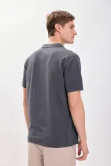 Remera polo de piqué color gris, con cuello y puños acanalados, de manga corta y corte clásico.