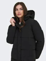 Campera puffer larga con capucha ajustable, cierre frontal combinado con cremallera y botones a presión, y puños internos. Diseño acolchado con bolsillos laterales.