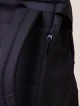 Mochila color beige con base de cuero sintético negro, de nylon ripstop con forro de poliéster.