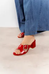 Sandalia color beige con tiras cruzadas y hebilla metálica cuadrada. Taco cuadrado de 6 cm.