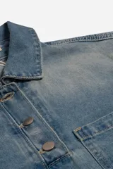 Camisa de jean con efecto lavado, cuello clásico, cartera de botones y bolsillo frontal. Presenta un corte cropped con ruedo desflecado.