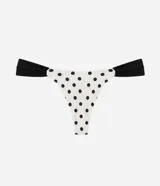 Bombacha de bikini de microfibra color blanco con estampado de lunares negros, modelo asa delta y laterales drapeados en contraste.