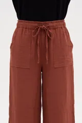 Pantalón de algodón color terracota, de tiro alto y calce holgado, con cintura elástica con cordón ajustable y bolsillos frontales aplicados.