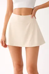 Falda mini de poliéster color beige, de corte evasé y cintura alta.