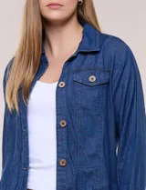 Campera de denim liviano azul, de corte clásico y silueta recta, con cuello camisero, cierre frontal con botones rústicos y bolsillos con solapa en el pecho.