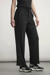 Pantalón deportivo de corte recto y tiro alto, con cintura elástica ajustable mediante cordón. Presenta aberturas laterales en el ruedo y bolsillos laterales.