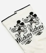 Medias de caña larga color blanco con borde superior negro, confeccionadas en tejido acanalado. Presentan un estampado lateral de Mickey Mouse con lettering en color negro.