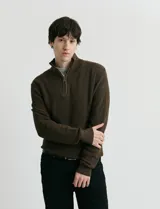 Cardigan de punto color marrón, con cuello alto y cierre frontal parcial. Presenta diseño en punto inglés en cuerpo y mangas, con terminaciones en punto canalé en cuello y puños.
