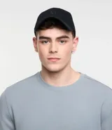 Gorra negra de sarga de algodón, con visera curva y bordado frontal con las letras "NY". Ajuste trasero con hebilla metálica.