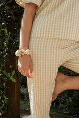 Pijama de algodón con estampado vichy, compuesto por una blusa de manga corta con volados y un pantalón capri con elástico en la cintura y volados en el ruedo.