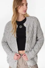 Cardigan tejido de punto gris, de corte relajado, con cuello redondo y cierre frontal de botones.