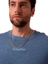Remera de corte relajado color azul grisáceo, con cuello redondo y mangas cortas. Presenta un bordado sutil con el nombre de la marca en el pecho y un parche tejido en la manga.