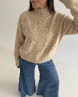 Sweater de punto color marrón con cuello alto y diseño bordado floral al tono en el frente y las mangas.