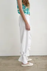 Pantalón recto marrón de lino y algodón, con tiras regulables en los tobillos para ajustar.