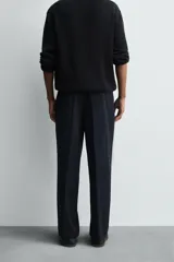 Pantalón de corte regular fit confeccionado en tejido ligero de lana de origen italiano. Presenta bolsillos frontales, bolsillos traseros de vivo con botón y cierre frontal con cremallera y botón.