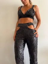 Top de bikini negro con lentejuelas, breteles anchos y espalda descubierta.