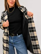 Chaqueta larga de corte recto con estampado de cuadros en tonos marrones y beige. Presenta solapas clásicas, cierre frontal con un botón, bolsillos laterales y forro interior.