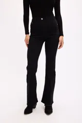 Jean de corte bootcut con tiro medio, confeccionado en denim con elasticidad. Presenta un ajuste entallado en cadera y muslos, con una leve apertura desde la rodilla hacia el ruedo.