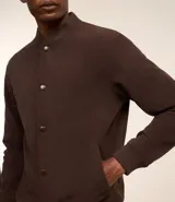 Campera bomber azul marino de pana con cuello redondo, cierre con botones a presión, bolsillos laterales y puños y cintura elastizados.