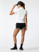Remera polo de piqué color blanco, con manga corta abullonada, escote en V profundo y cuello clásico.