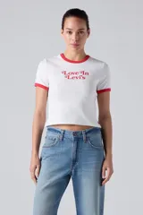Remera corta de corte ajustado, color blanco con cuello redondo y ribetes en las mangas de color rojo. Cuenta con estampa frontal con la frase "Love In Levi's" en tono rojo.