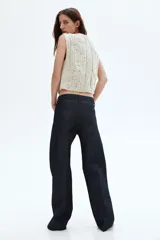 Jean de cinco bolsillos en denim de algodón color azul oscuro, de tiro medio y pierna recta muy ancha. Presenta pliegues cosidos marcados en el frente de cada pierna.