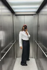 Camisa blanca de popelina de algodón, con cuello solapa, escote pico, manga larga con puños y cierre frontal con botones.