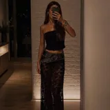 Pollera larga de encaje negro con diseño semitransparente y cintura elástica.
