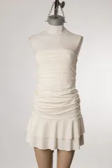 Vestido corto strapless color negro, con corte ajustado en el torso y falda con volados.