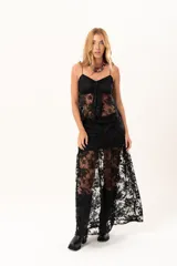 Pollera larga de encaje negro con silueta fluida y diseño asimétrico. Presenta un forro interno hasta la altura del frunce, dejando la parte inferior con transparencias que aportan movimiento.