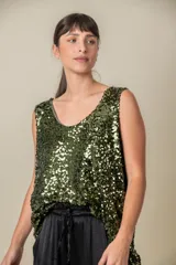 Blusa sin mangas confeccionada en tela cubierta de lentejuelas doradas y plateadas, con escote redondo y corte holgado.