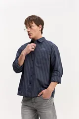Camisa de manga larga con diseño a rayas verticales en color verde y blanco, cuello clásico y estampa con bordado en la espalda con la frase "Expect Nothing, appreciate everything".