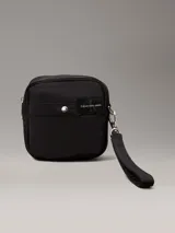 Riñonera negra de poliéster reciclado con correa ajustable con clip, cierre de cremallera en la parte superior y dos bolsillos exteriores en la parte delantera con anillas en D. Se pliega y se cierra con cremallera para crear una cartera para la muñeca.