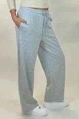 Pantalon deportivo de corte recto y tiro medio, confeccionado en tejido de algodón con cintura elástica y cordón ajustable. Presenta un diseño holgado y cómodo.
