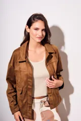 Sobrecamisa marrón de gamuza sintética, con cuello camisero, cierre frontal con botones, mangas largas con puños abotonados y bolsillos de parche en el pecho.