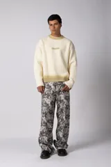 Sweater de punto acanalado con diseño degradado de negro a gris en el cuello y el ruedo. Presenta un corte regular y un pequeño bordado central en el pecho.