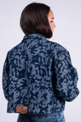 Campera corta de denim con estampado camuflado en tonos de azul, cierre frontal completo y bolsillos en el pecho.