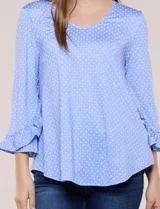 Blusa celeste con estampado de lunares blancos, cuello en V y mangas 3/4 terminadas en volados.