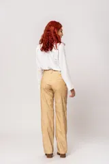 Pantalón de tiro alto color beige con estampado difuminado, bolsillos laterales y cierre frontal con cremallera y botón.