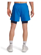 Shorts deportivos Under Armour 2 en 1, compuestos por un short exterior ligero de color azul y un short de compresión interior integrado de color azul marino. Presenta cintura elástica con cordón, bolsillos laterales y logotipo reflectante.